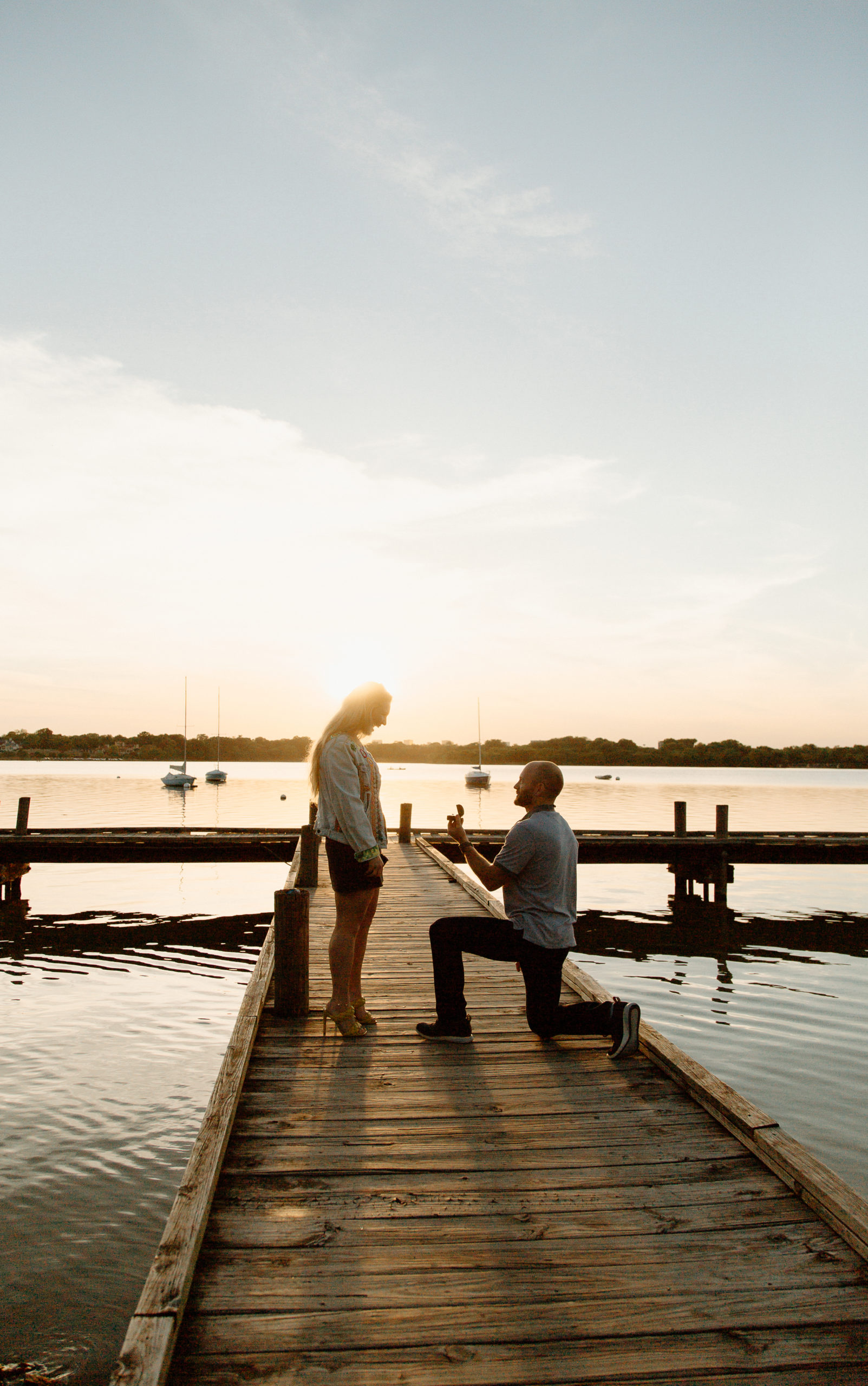 Guy proposes to girlfriend on dock at White Rock Lake in Dallas, Texas at sunset.