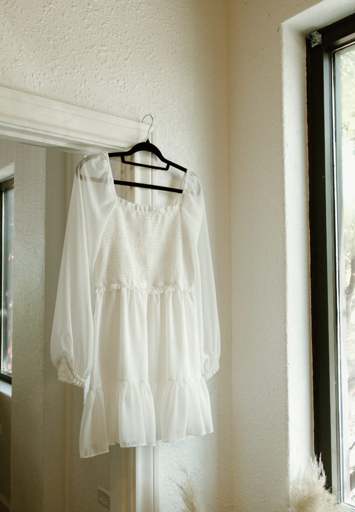 The untraditional, short wedding dress hands in the doorway. 