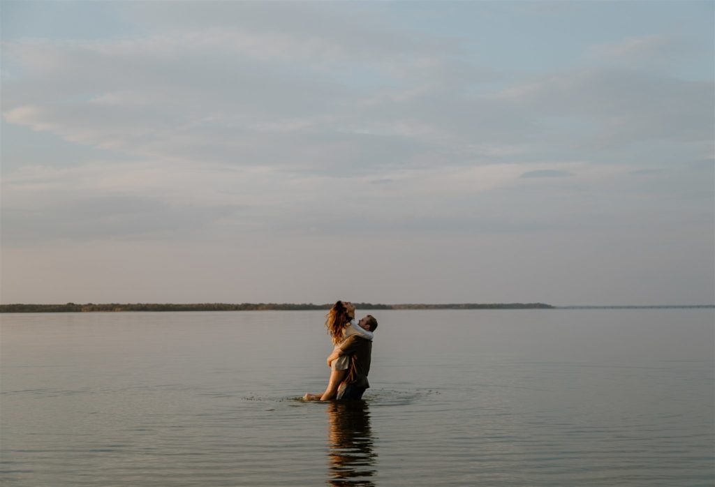 Couple spinning in Lake Tawakni during engagement photos.