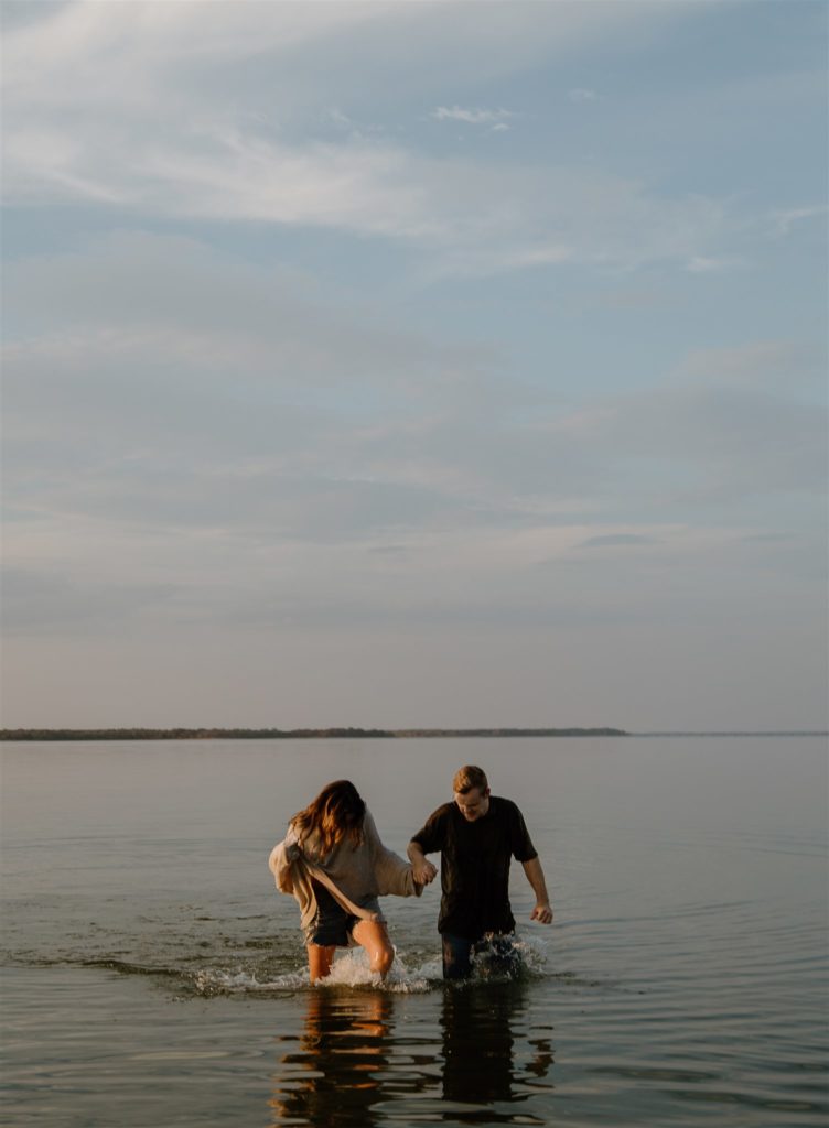 Couple running out of Lake Tawakoni during engagement photos.