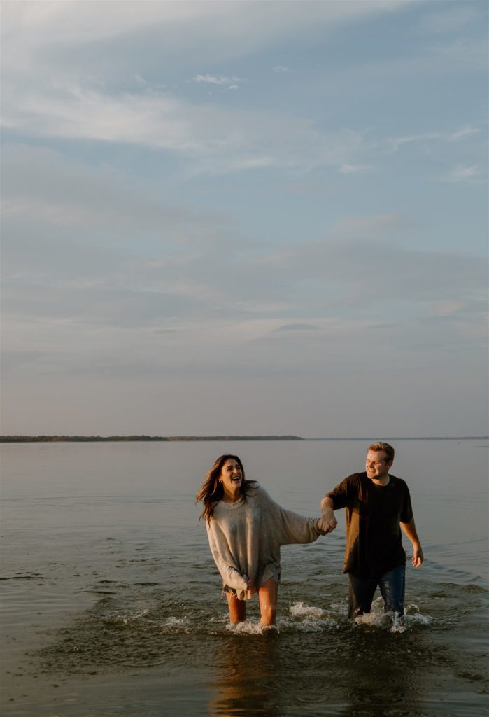 Couple laughing in Lake Tawakoni during engagement photos.