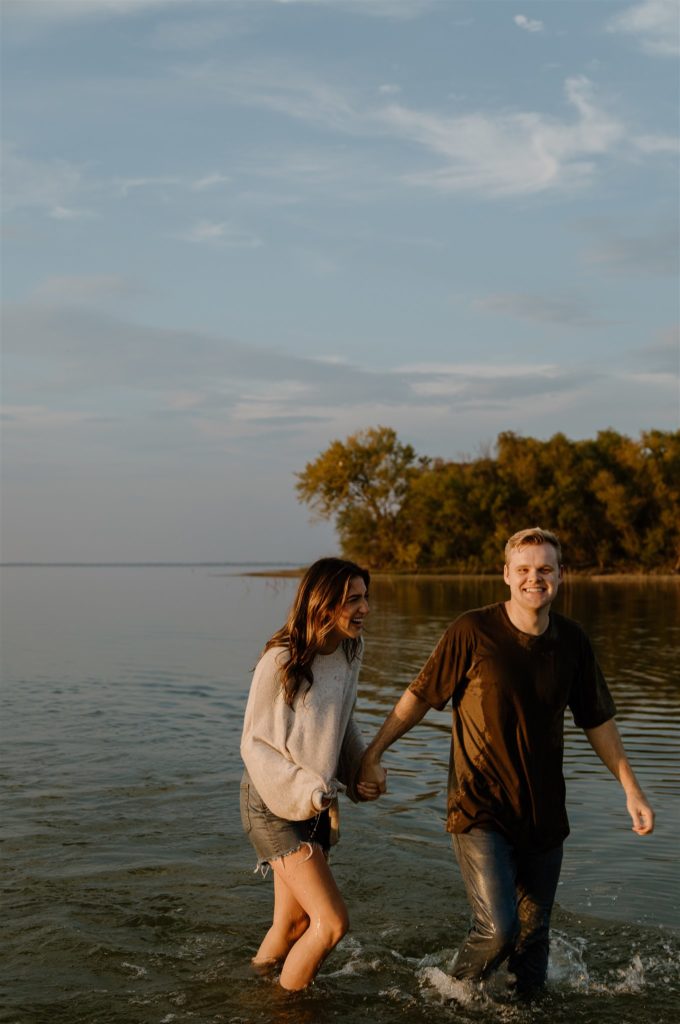 Couple laughing at the camera in Lake Tawakoni during engagement photos.