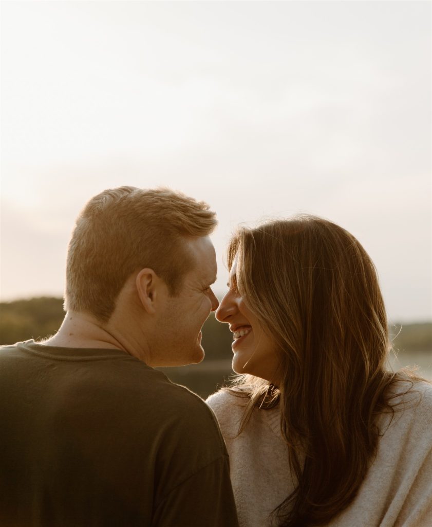 Couple smiles at each other in Canton, Texas during engagement shoot.