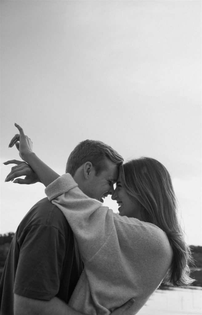 Couple laughing at engagement shoot at Lake Tawakoni State Park in black and white.