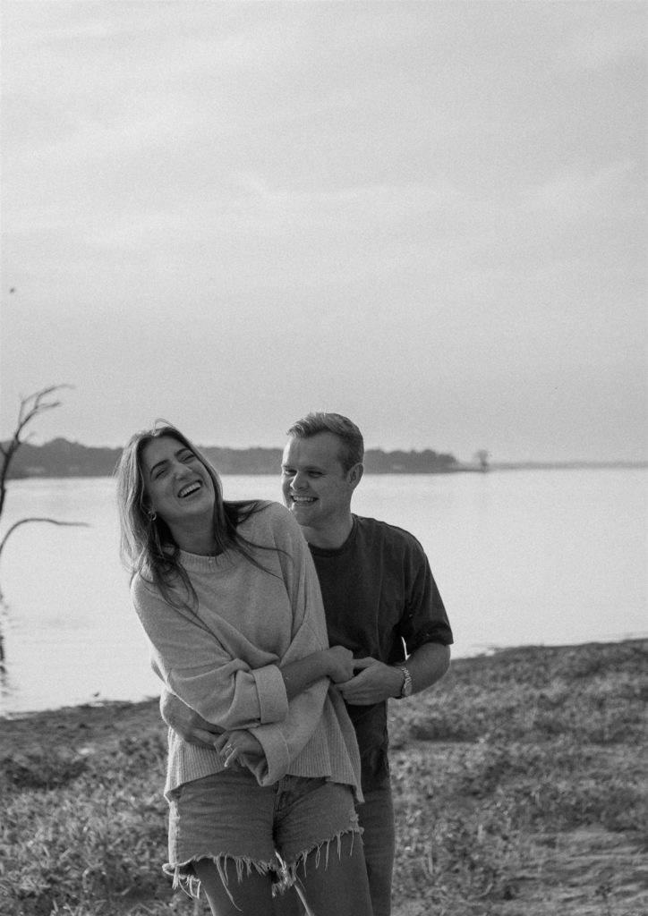 Couple laughs during engagement photos in Canton, Texas in black and white.