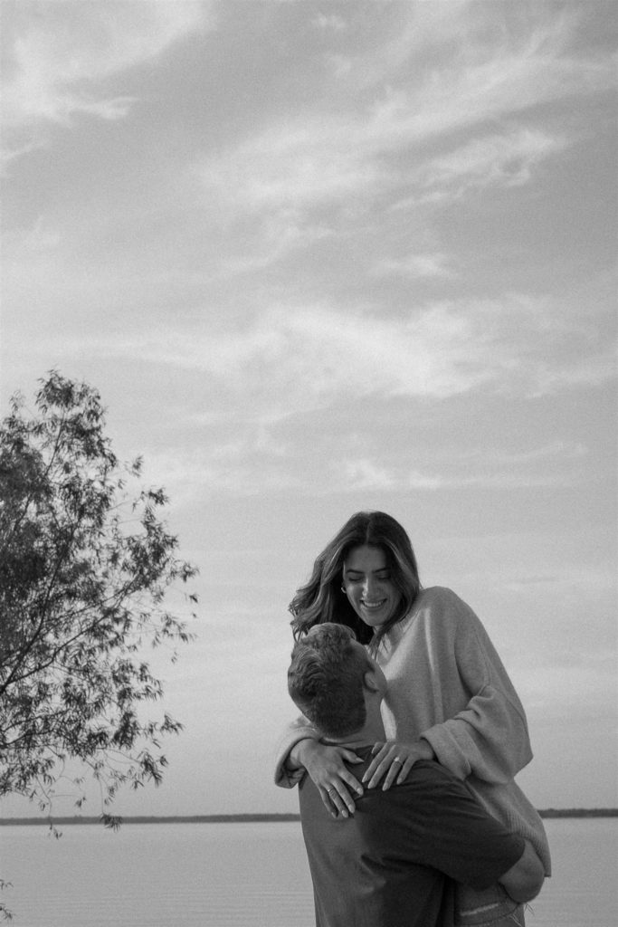 Black and white of couple spinning during engagement photos.