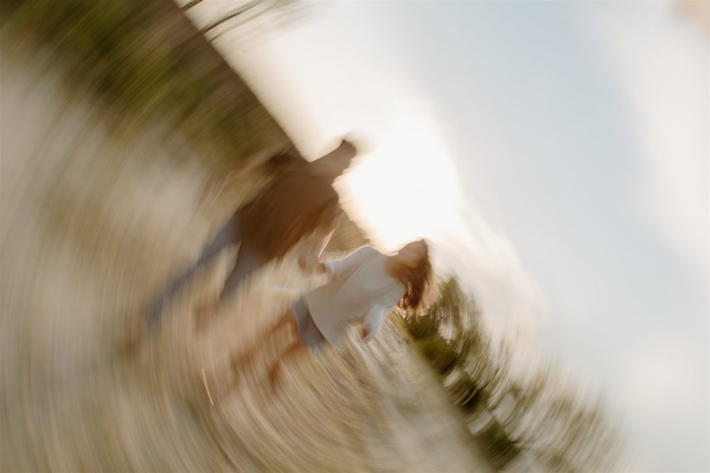 Motion blur of couple running towards camera during engagement photos at Lake Tawakoni State Park.