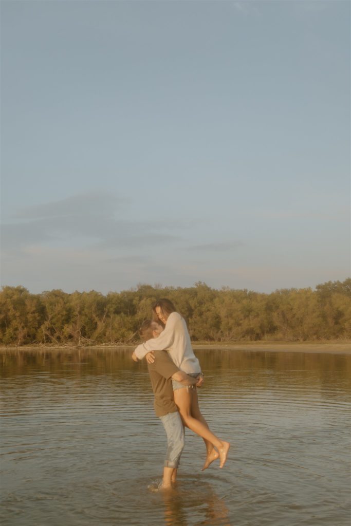 Couple spinning in the water at Lake Tawakoni State Park during engagement photos.