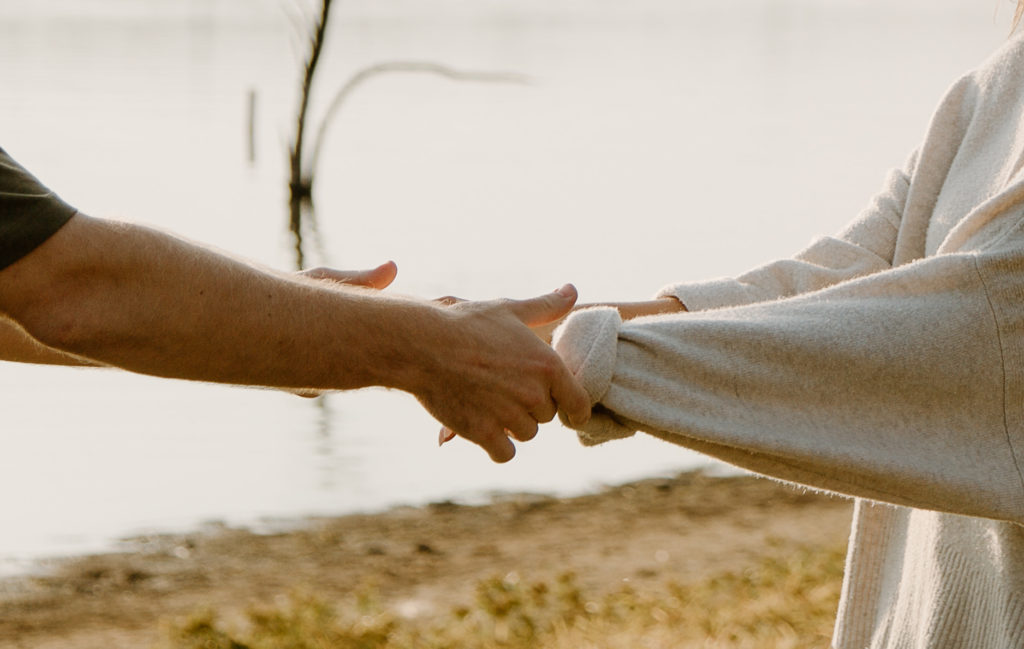 Details of couple holding hands during engagement photos.