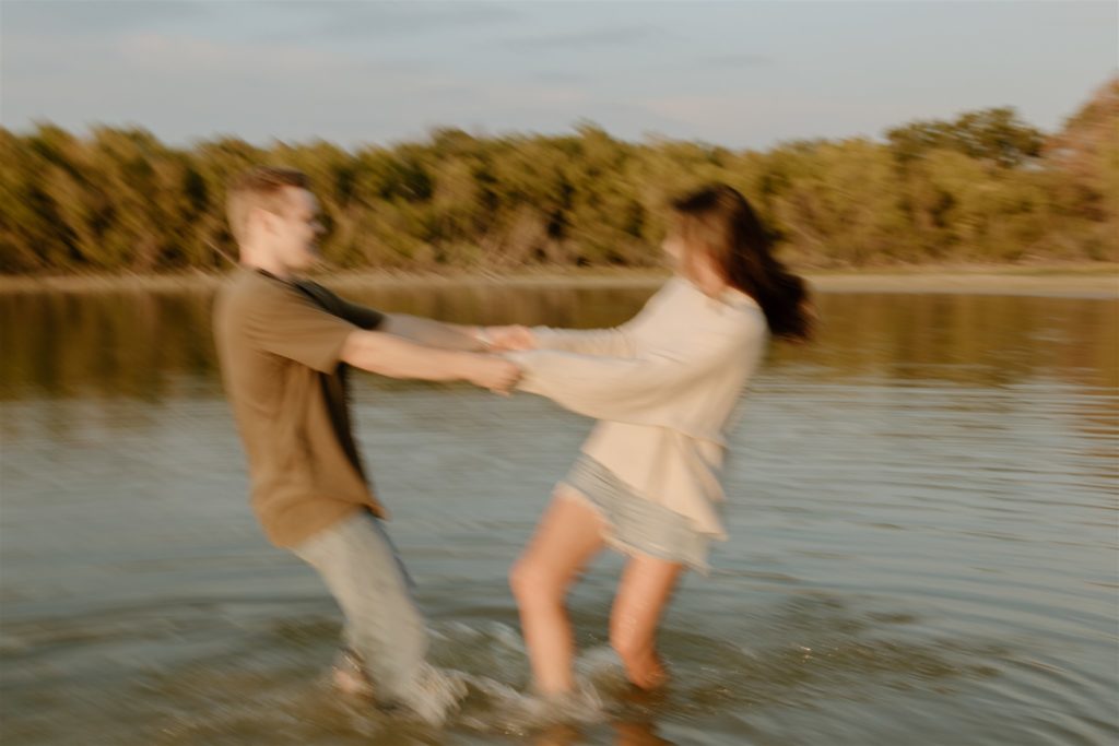 Couple spins around in lake motion blur.