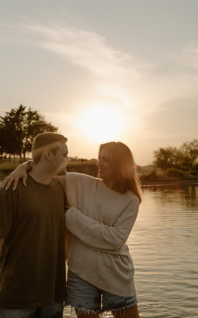 Couple hanging out during engagement photos on beach.