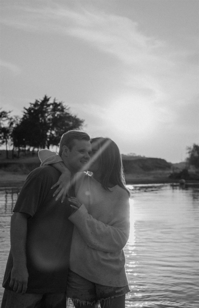 Couple whispering to each other during engagement photos at Texas beach.