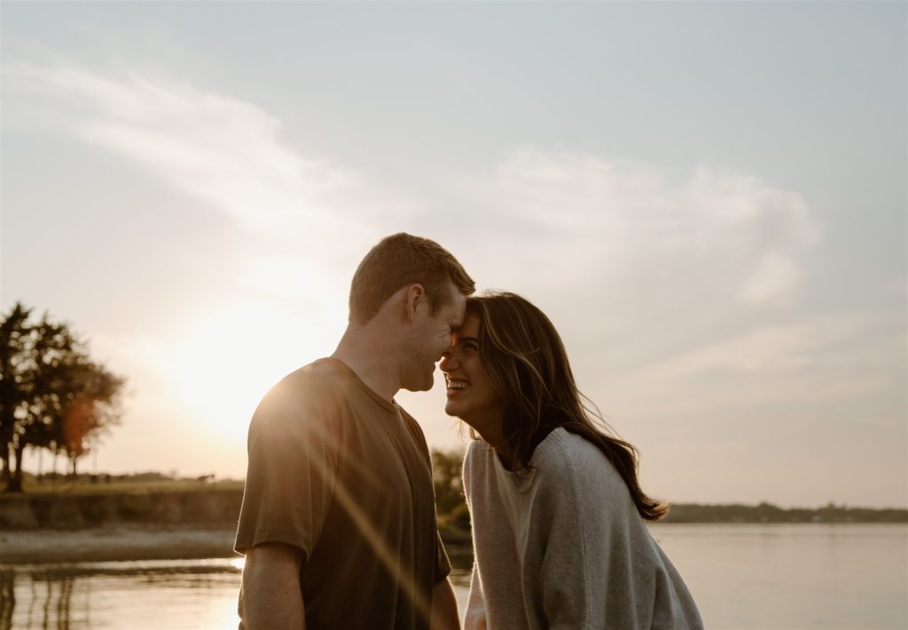 Couple laughing during golden hour engagement photos.