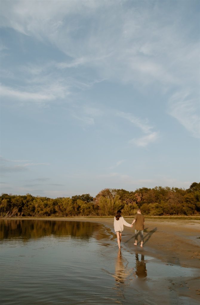 Couple walking together on beach at Lake Tawakoni State Park.