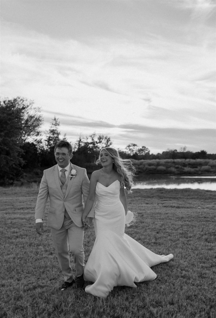 Bride and groom walk towards camera after texas wedding ceremony in black and white.