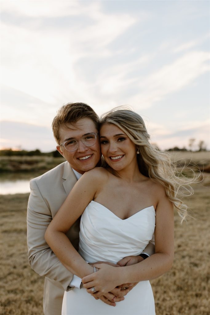 Bride and groom smile at camera during texas wedding ceremony.