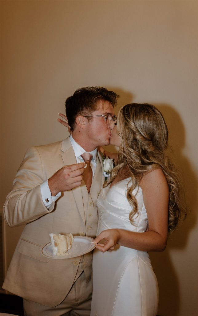 Bride and groom kiss after cake cutting at texas wedding reception.