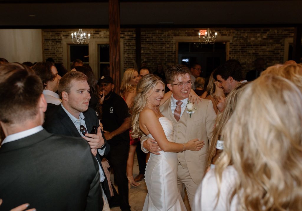 Bride and groom laughing during texas wedding reception.