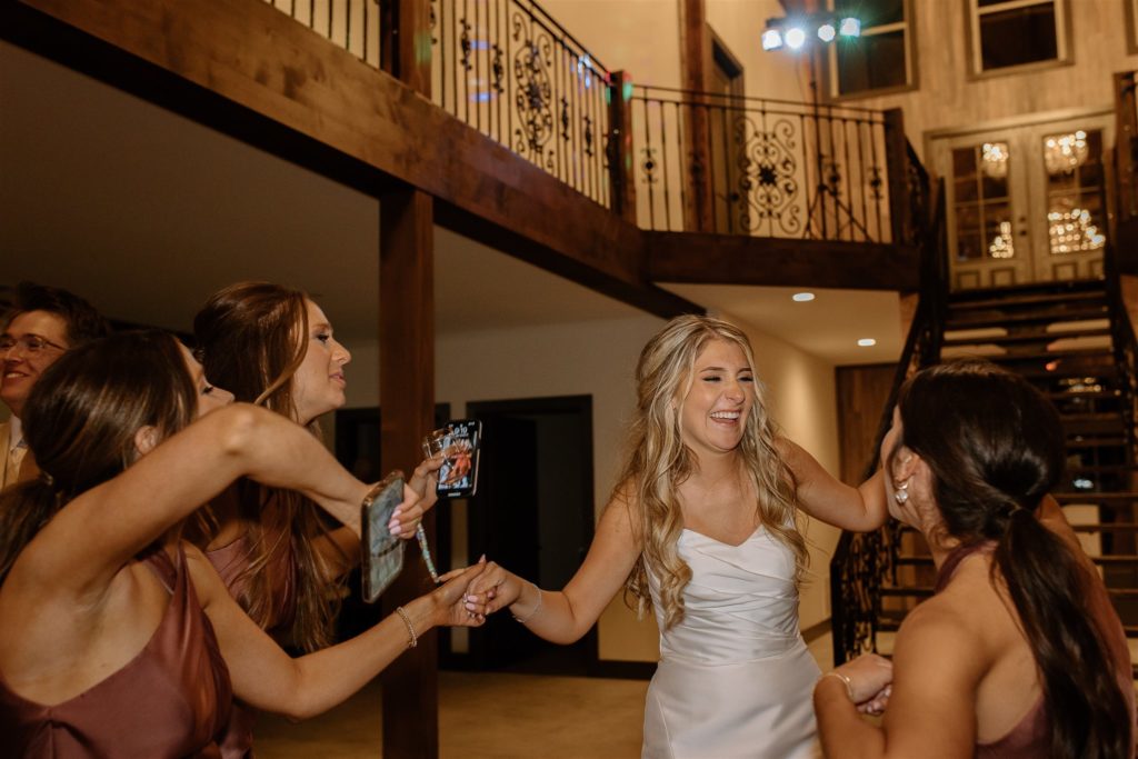 Bride dances with bridesmaids at texas wedding reception.