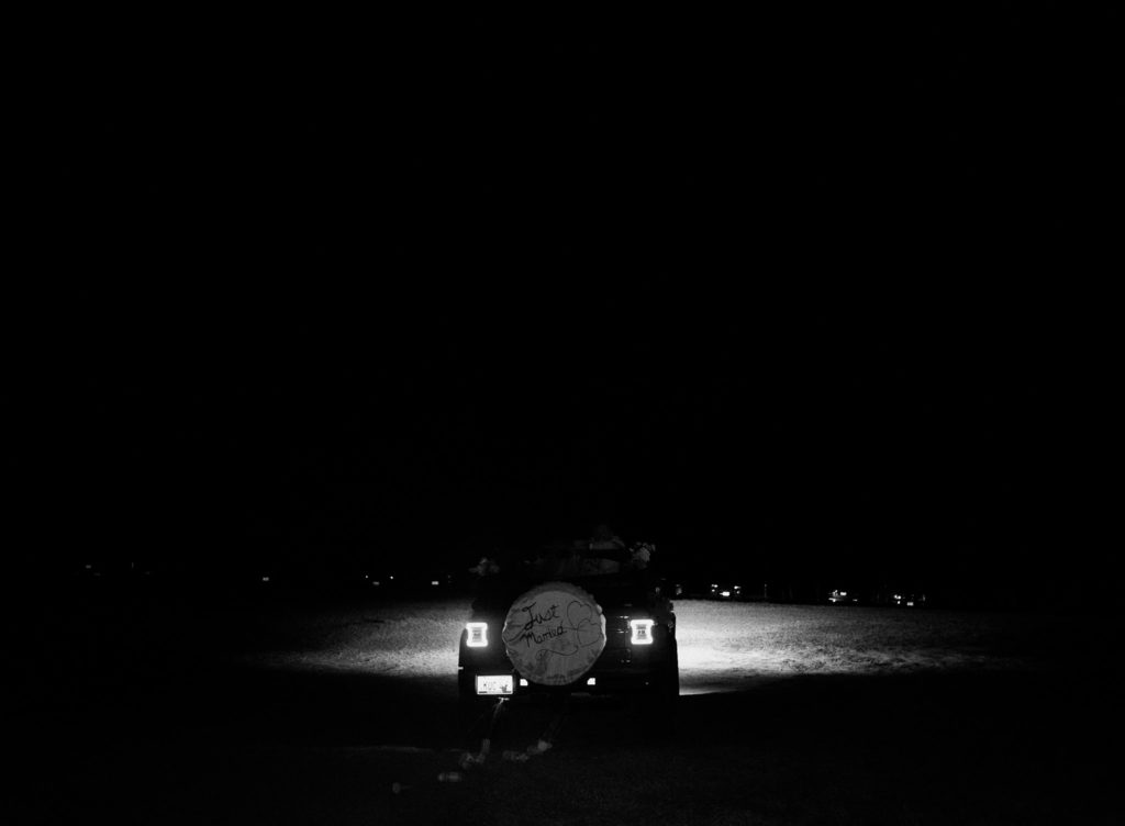 Bride and groom drive away in wedding getaway car after Texas wedding reception.