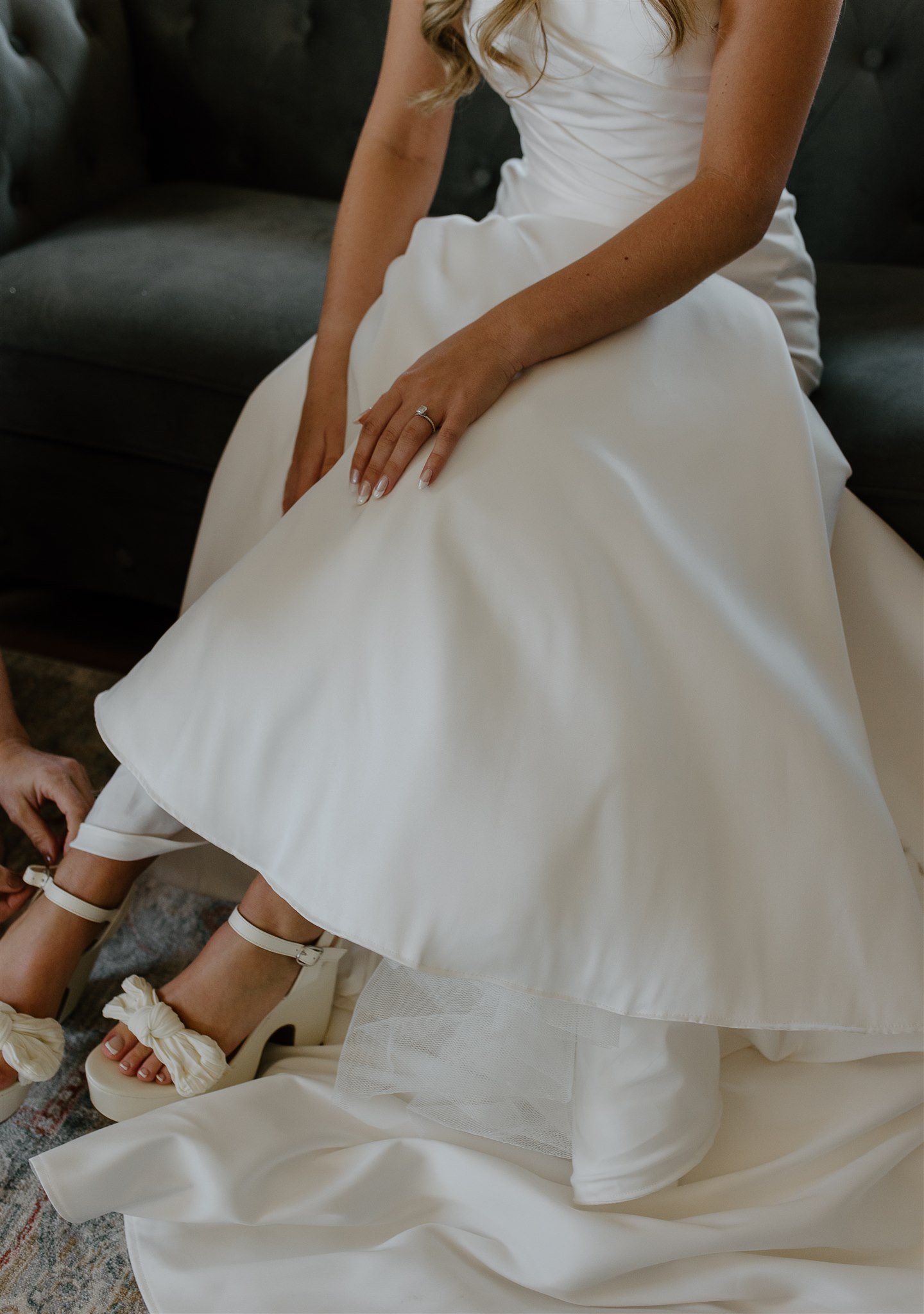 Bridal details as bride puts on unique heels on her wedding day.