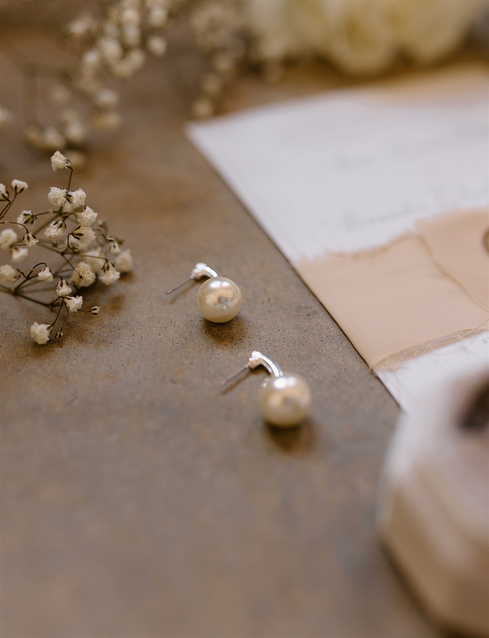 Elegant Flatlay Wedding Details with Pearl Earrings.