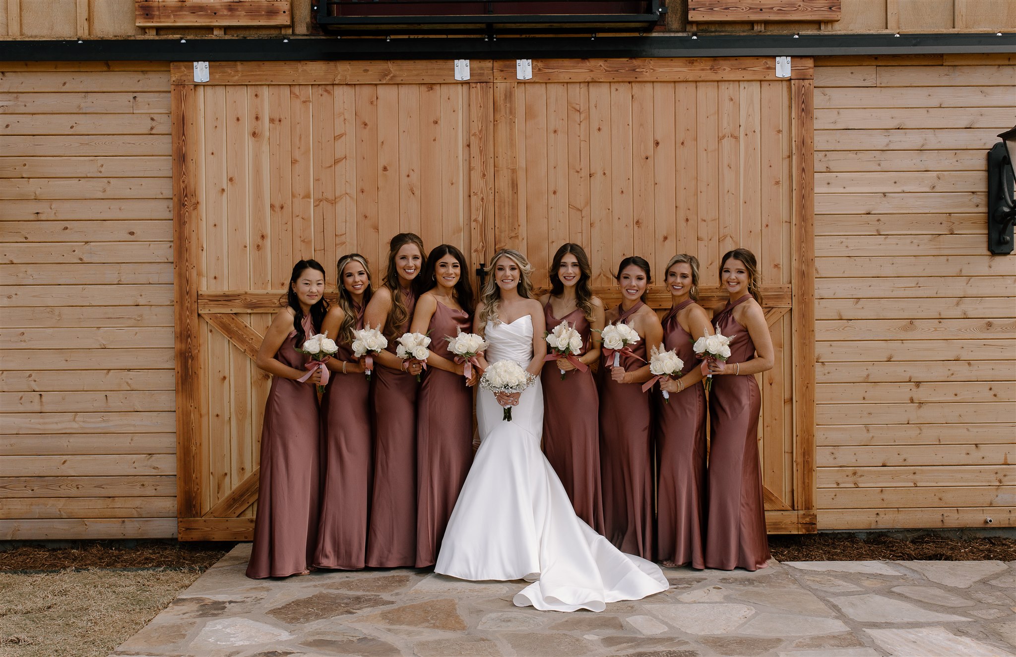 Fall inspired bridal party poses in front of The Orchard Barn.