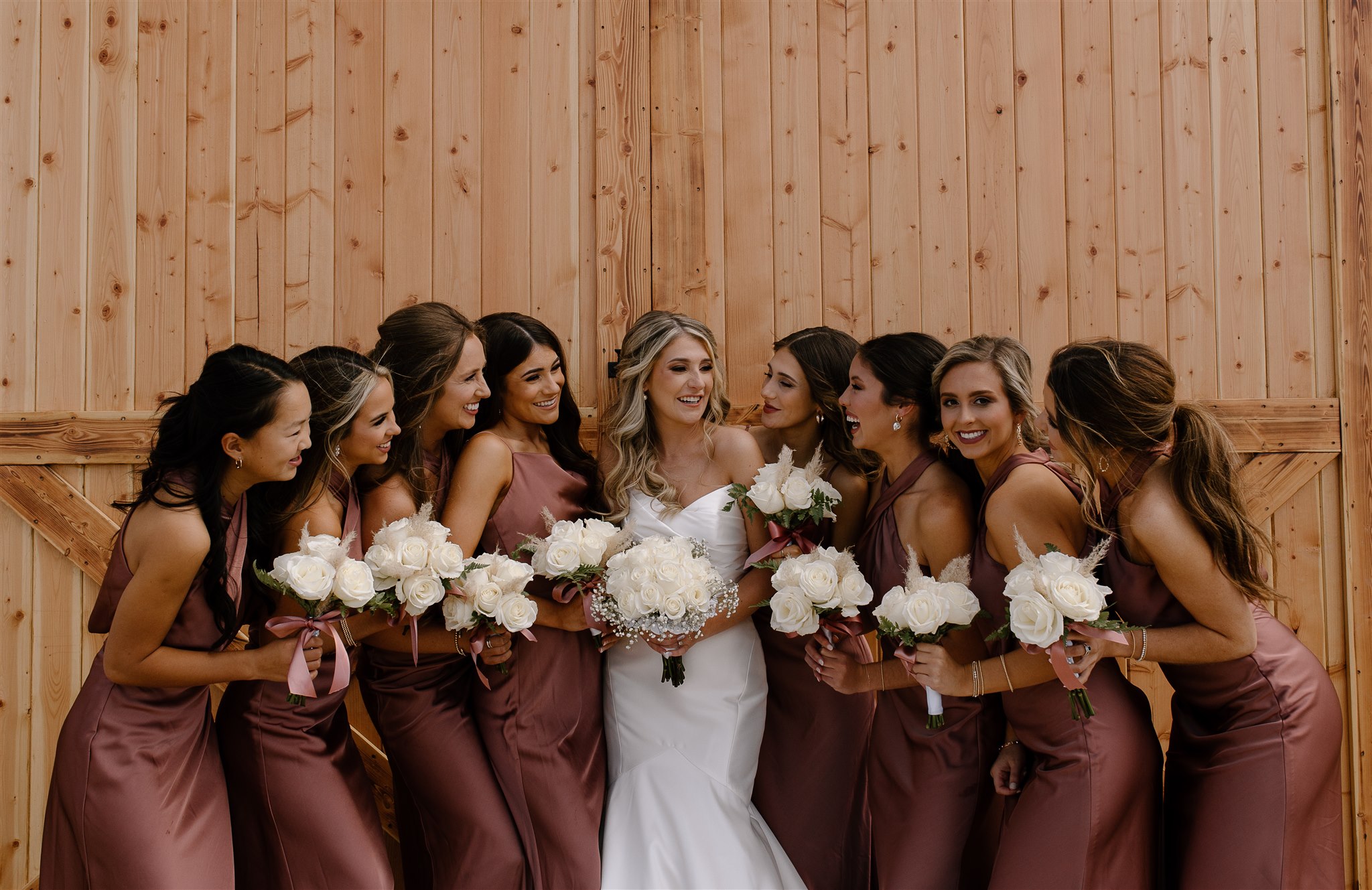 Bridal party laughes candidly with bride at The Orchard Barn.