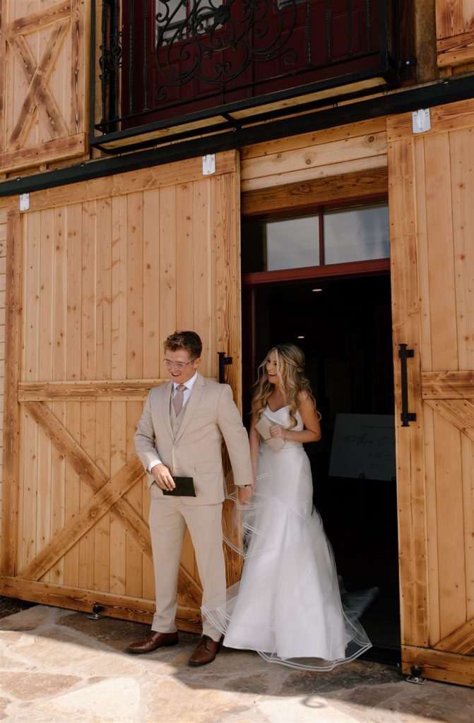 Bride looks at groom while exchanging vows in wedding attire during their texas wedding.