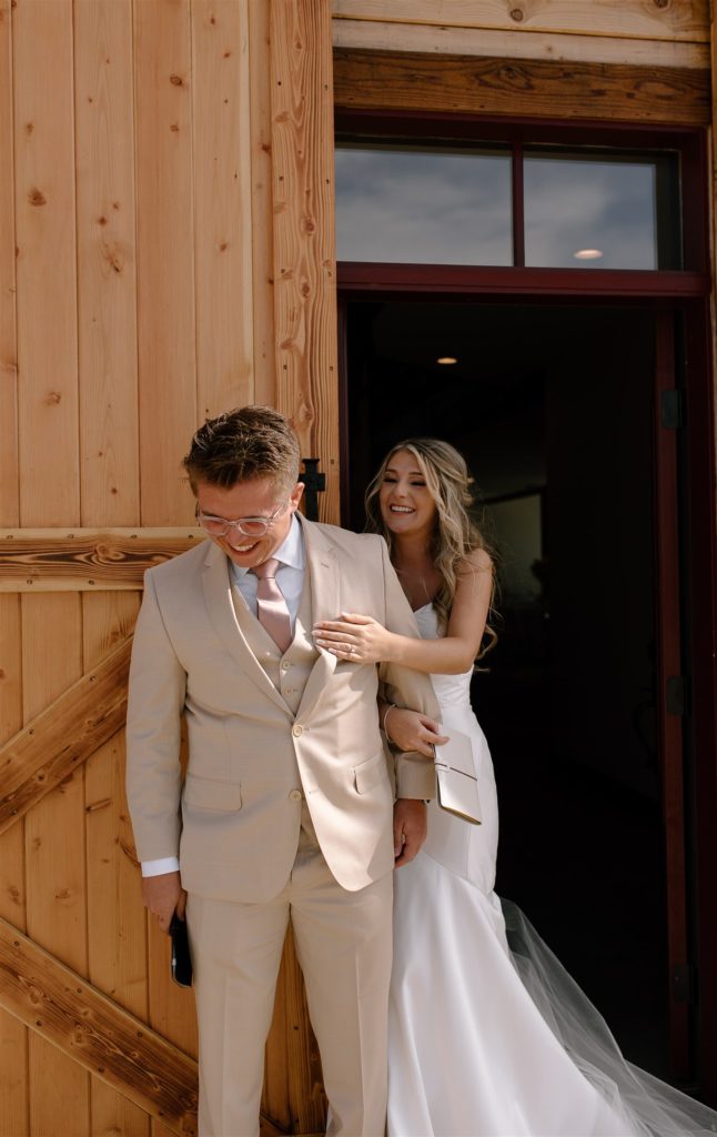 Bride laughs at groom during first touch.