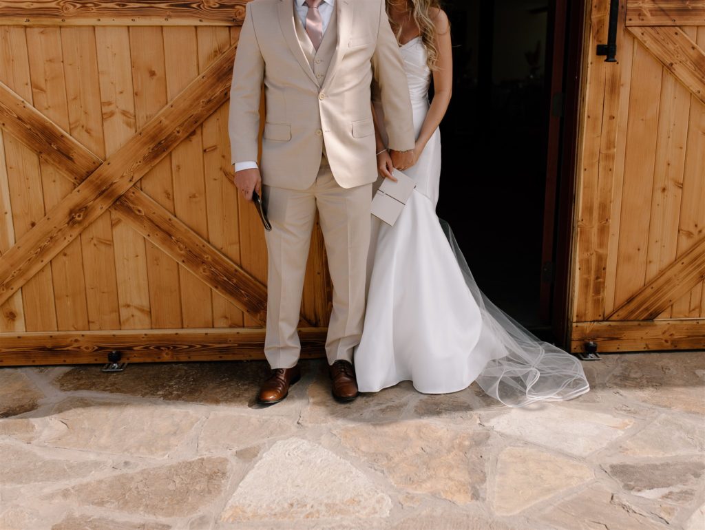 Details during bride and groom's first touch in wedding attire.