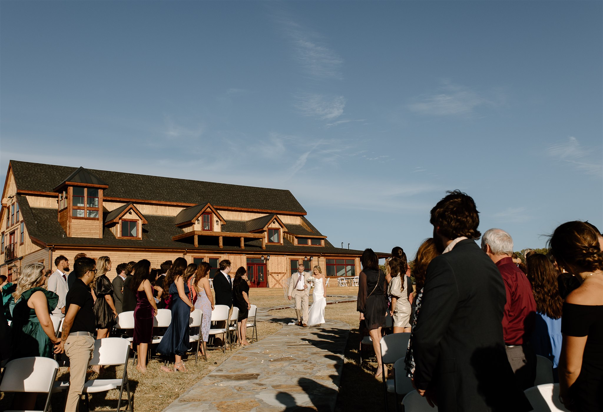 Bride walks down the aisle during texas outdoor wedding ceremony.