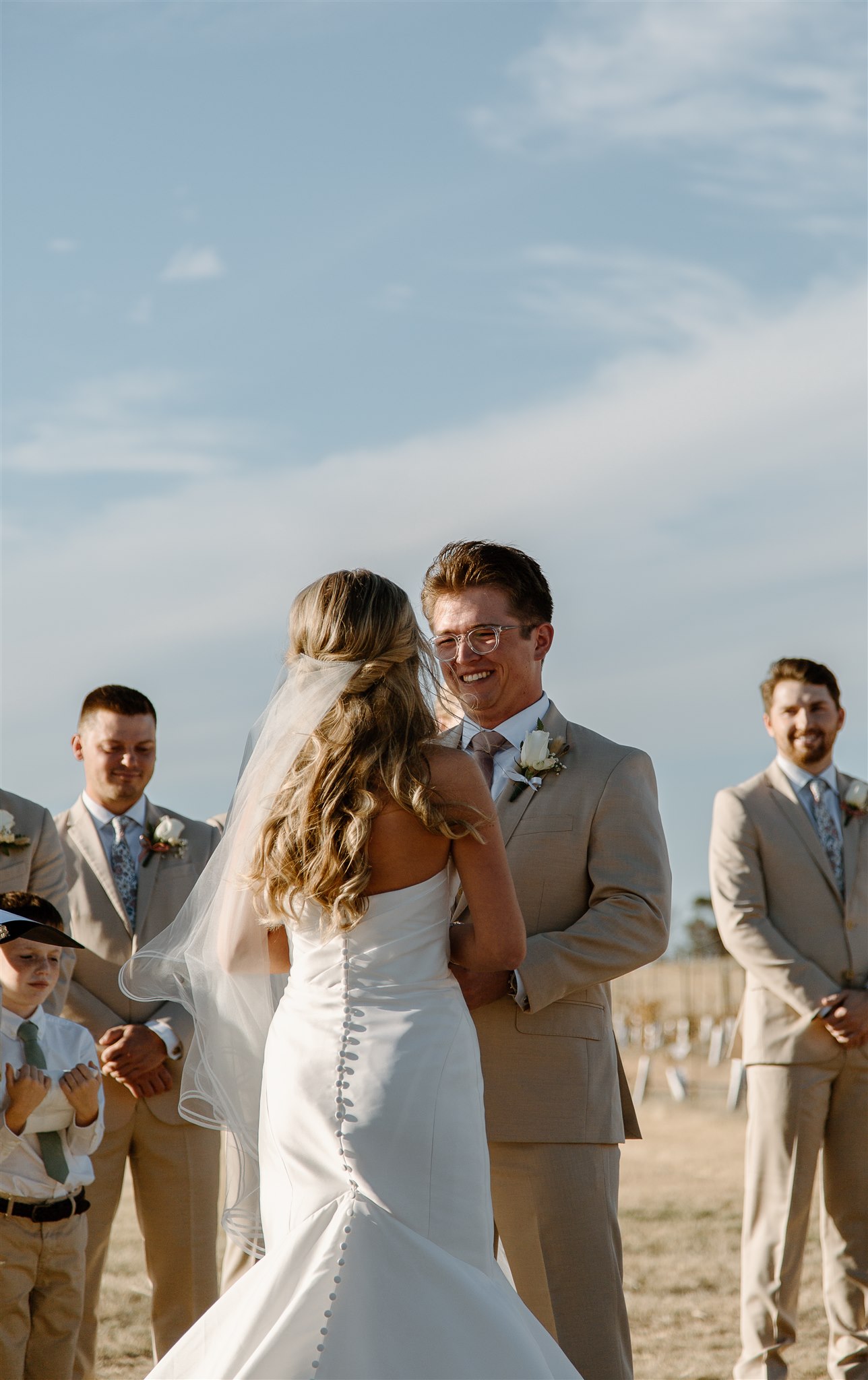 Groom smiles at bride during texas wedding ceremony.