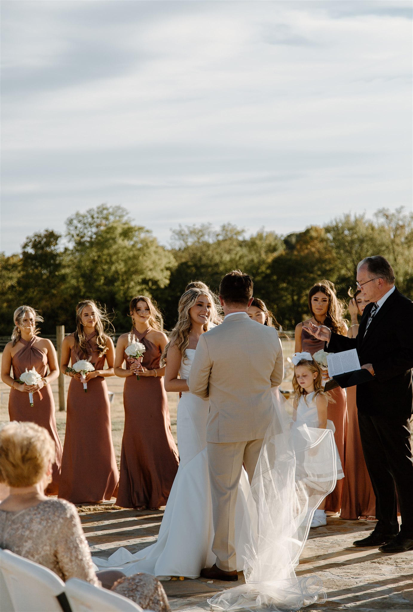 Bride smiles at groom during Texas wedding ceremony.