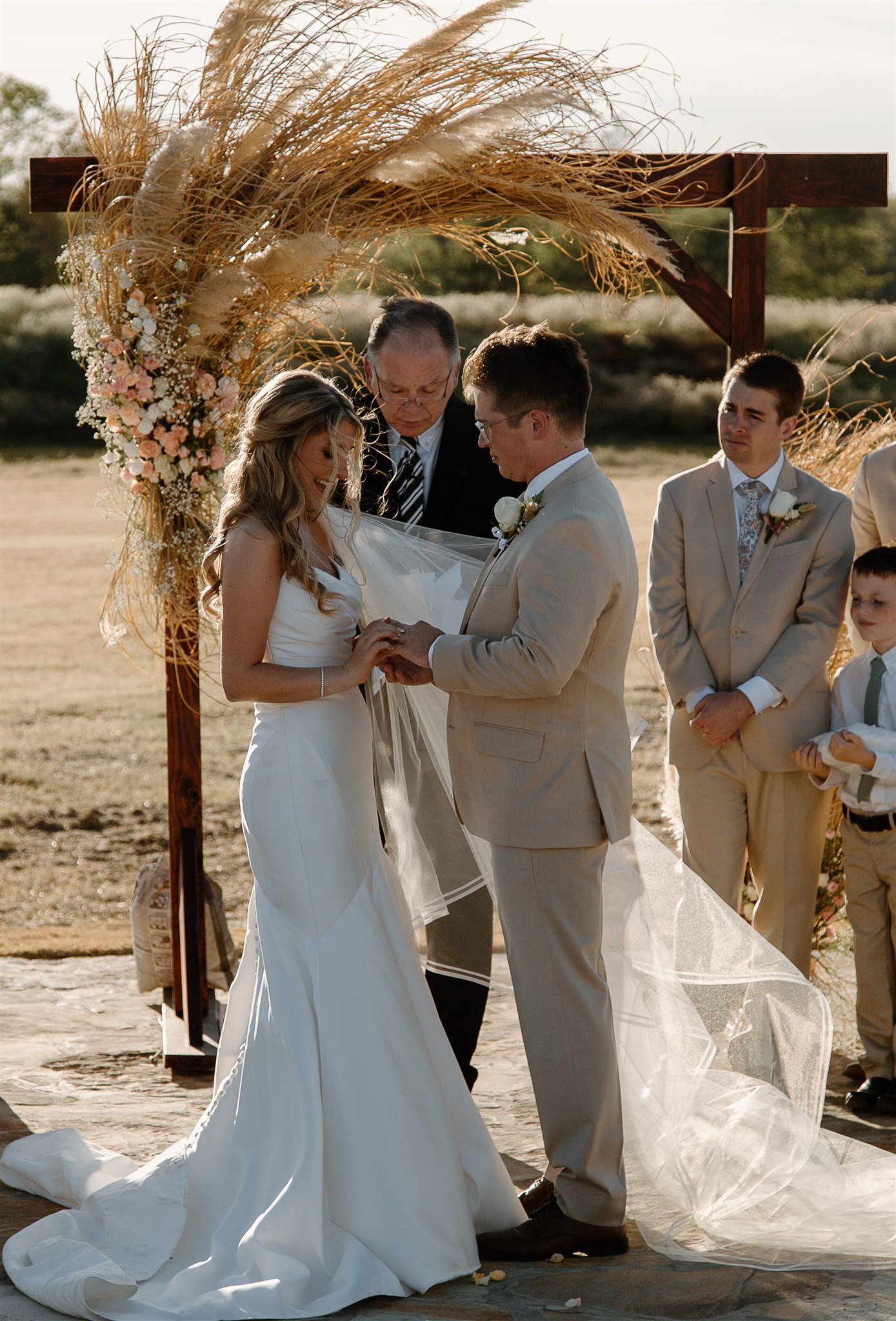 Bride places wedding ring on Groom's ring finger during texas wedding ceremony.