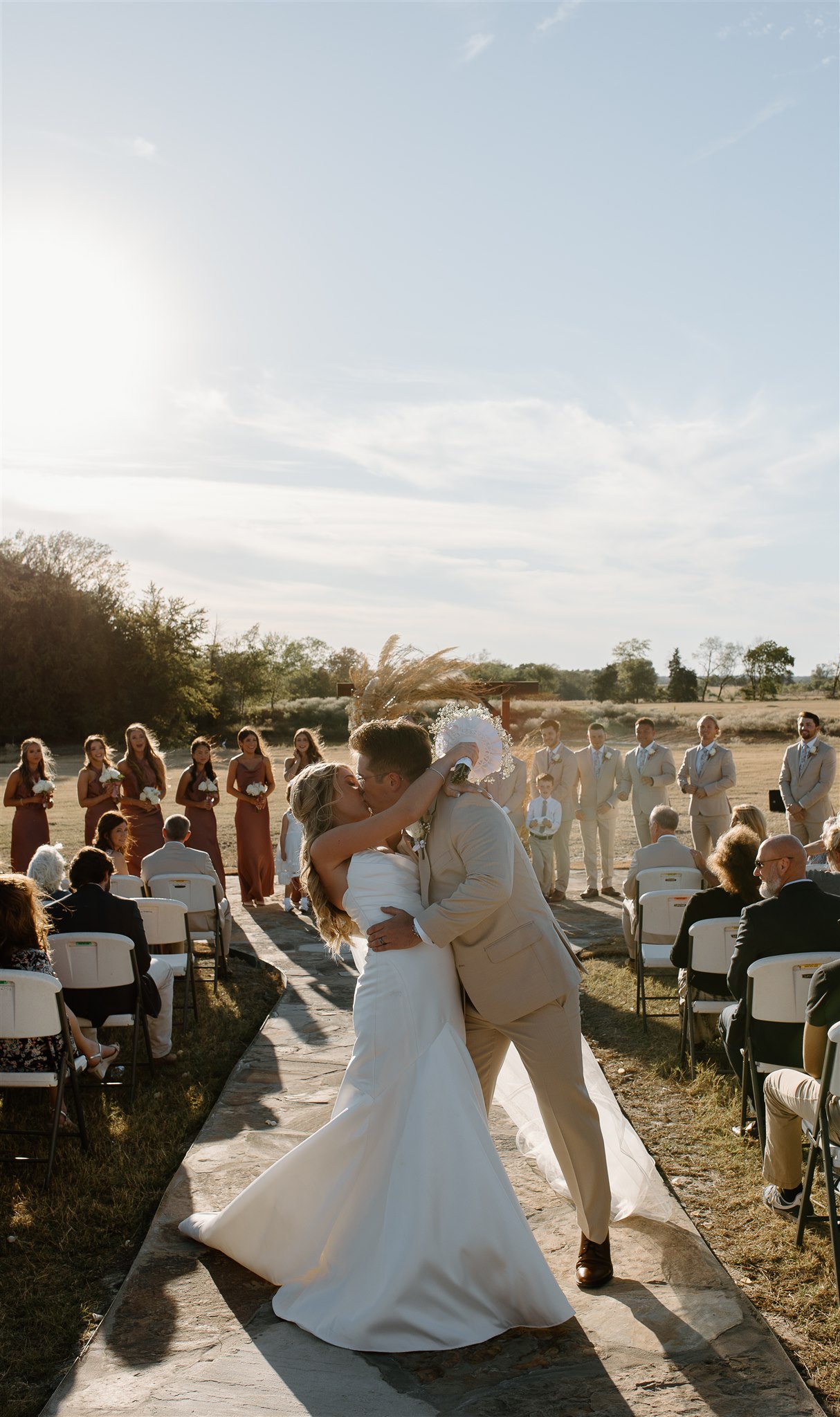 Bride and groom exit wedding ceremony with a kiss at the end of the aisle.