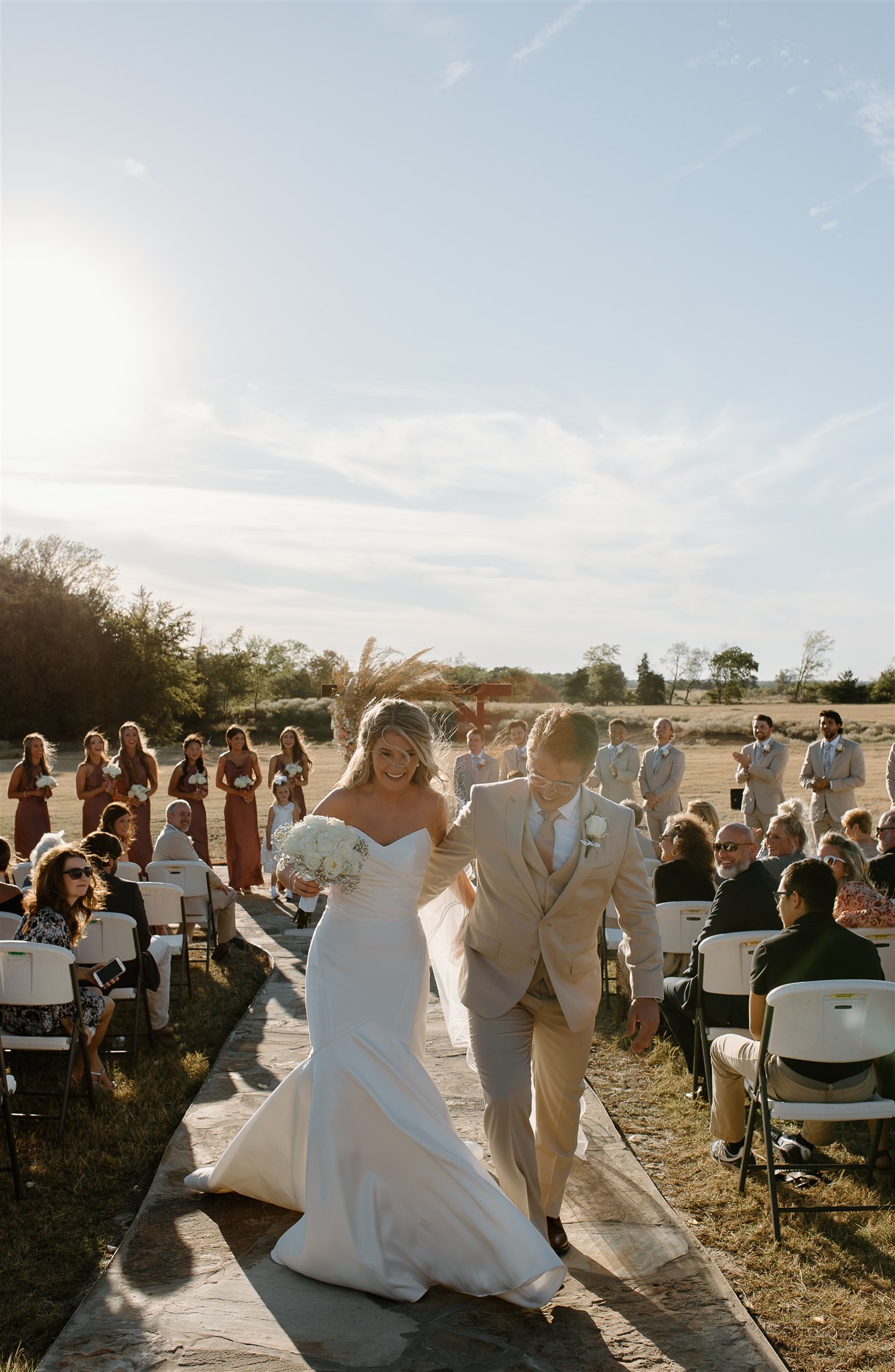 Bride and groom candidly laugh as they exit their texas wedding ceremony.