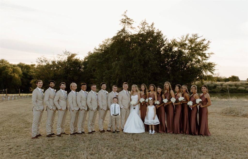 Texas wedding party stands in vineyard for portraits.