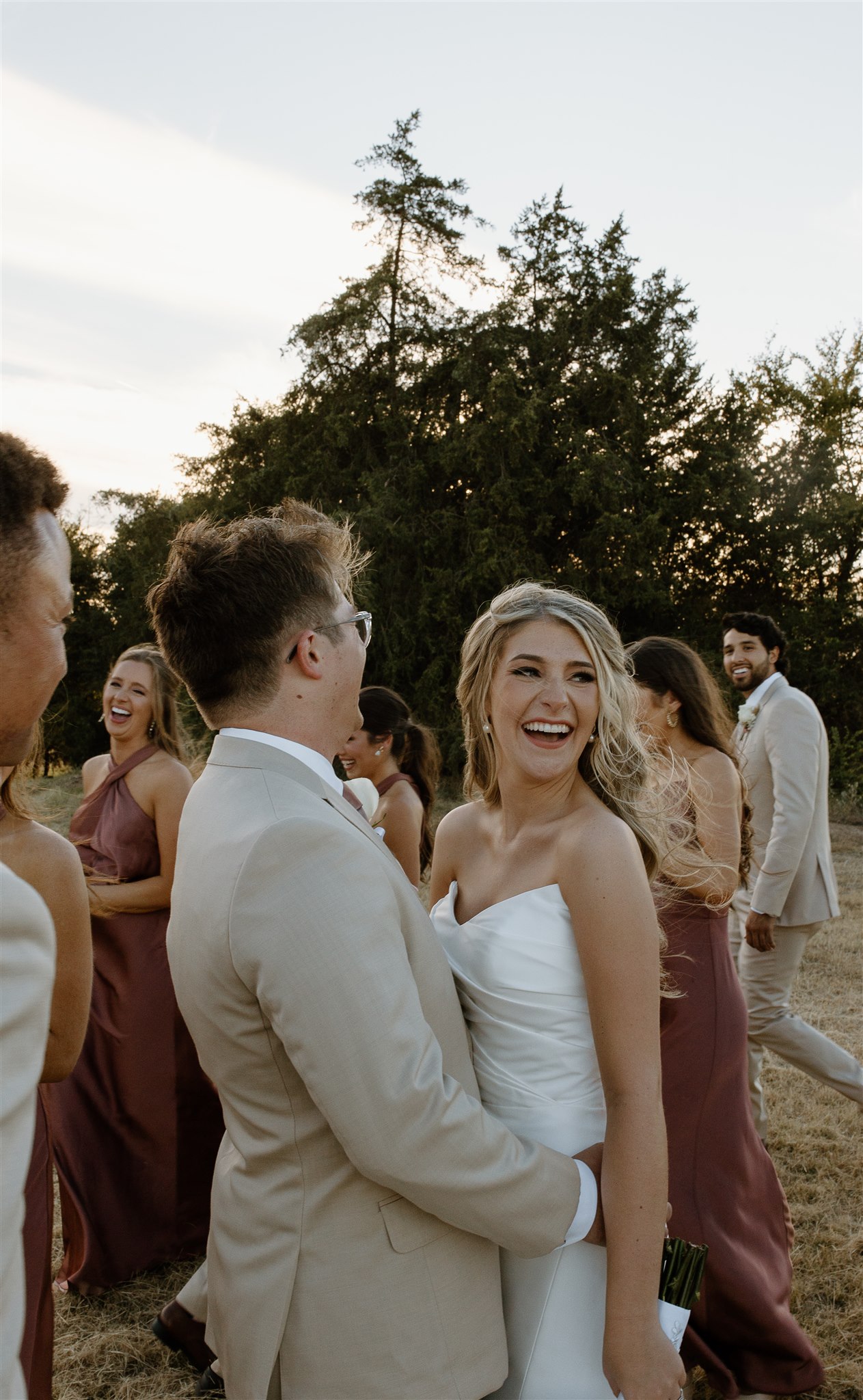 Wedding party walks around bride and groom during creative motion blur.