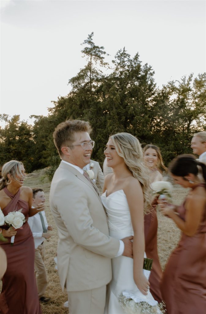 Wedding party walks around bride and groom during creative motion blur photo.