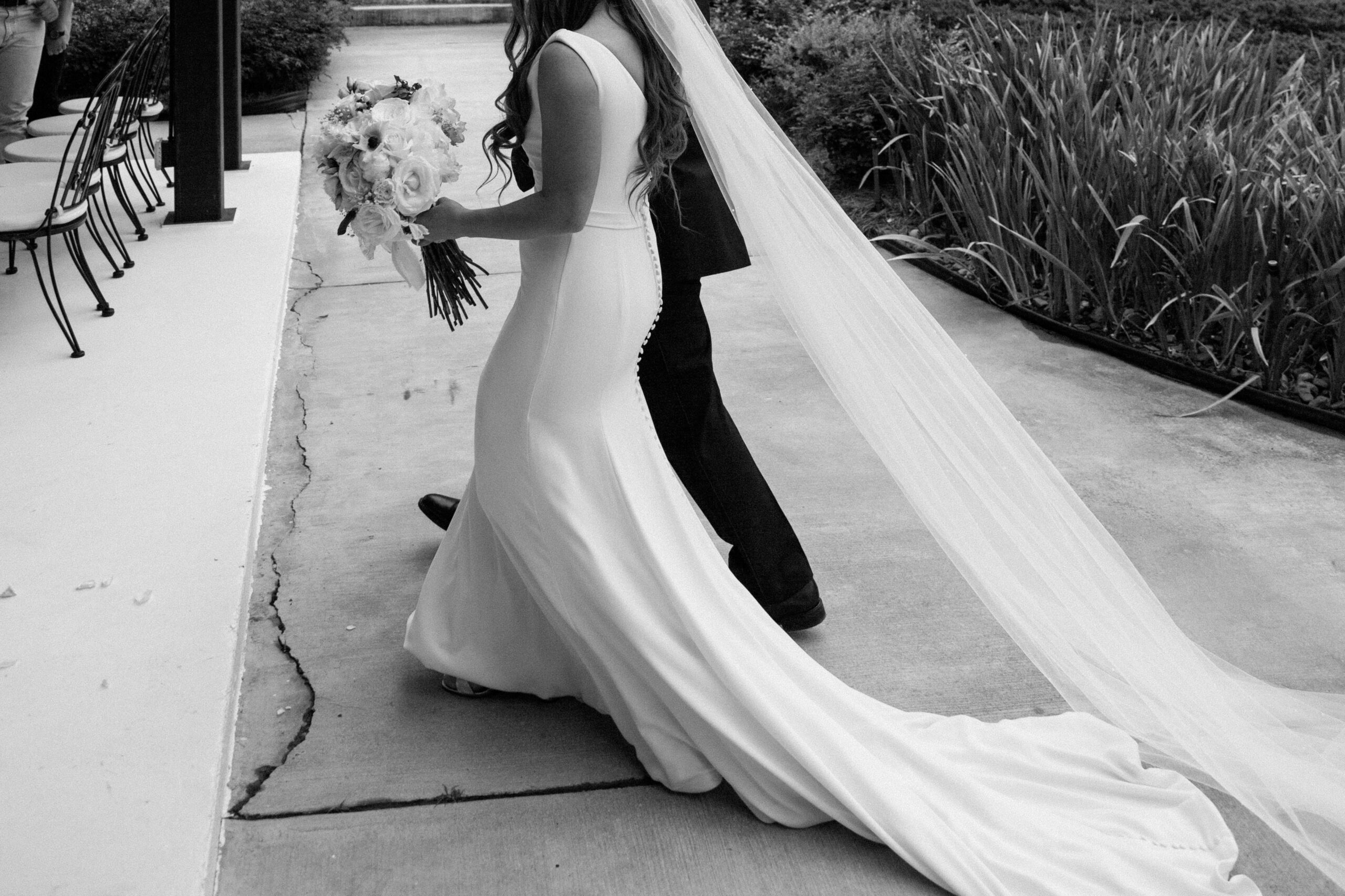 Black and white image of a father walking a bride down the aisle at a destination wedding.