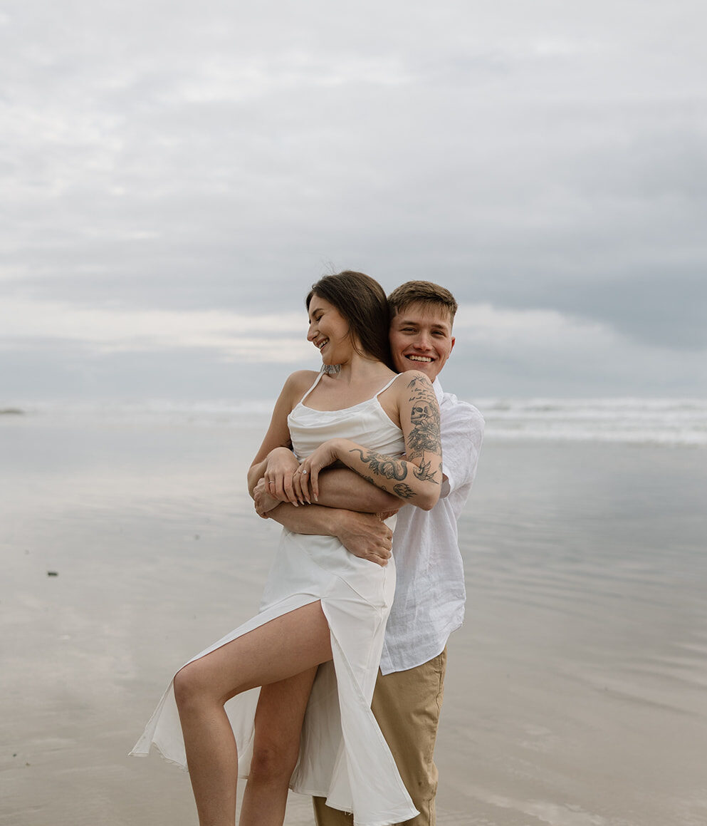 A couple takes their engagement photos at Hug Point on the Oregon Coast.